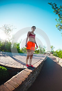 The girl is walking along the parapet.