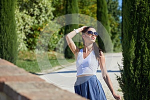 Girl is walking along the road among the fields