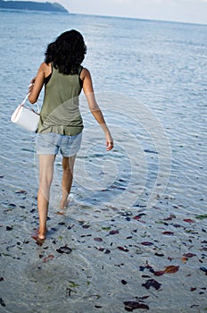Girl Walking Angrily with her Bag on a Beach photo