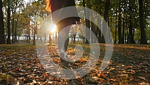 Girl walking in the autumn park. Beautiful sunset. Beautiful place. The camera is in motion. Slow motion