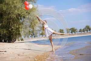 Girl walking on the beach with balloons