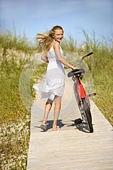 Girl Walking Bike on Boardwalk.