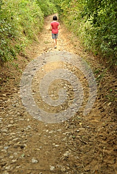 Girl walking on a countryside small road