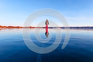 Girl walking on cracked ice of a frozen lake Baikal