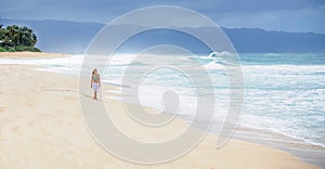 Girl walking on deserted beach photo