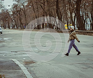 Girl walking down the street. Woman on crossroads in downtown. Big city lifestyle. Street fashion. Urban lifestyles.