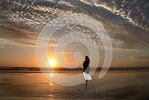 Girl walking and enjoying on beautiful beach at sunrise.