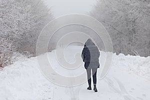 Girl walking in the forest with snow