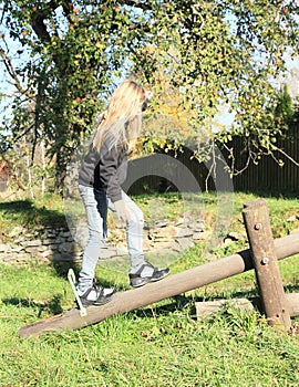 Girl walking over wooden swing