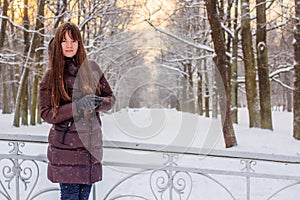 A girl is walking in the park in winter