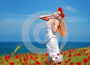 Girl walking in poppy field