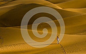 The girl walking on the sand dunes