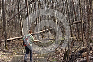 A girl walking through the swamp in the woods