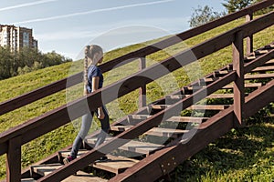 Girl walking up wooden stairs