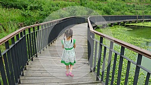 Girl walking on the wooden footbridge photo