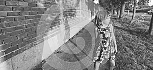 The girl walks along the road, waving her arms. Black and white monochrome image. Styled in retro or vintage style