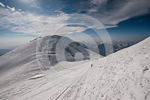 A girl walks along the snow-covered slope of Elbrus