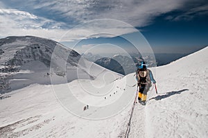 A girl walks along the snow-covered slope of Elbrus