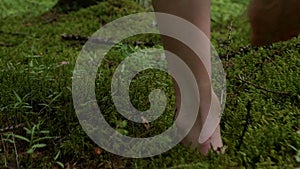 Girl walks barefoot in the woods in a cloak