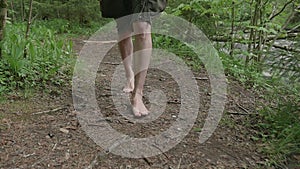 Girl walks barefoot in the woods in a cloak