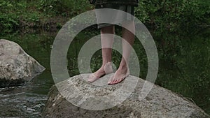 Girl walks barefoot in the woods in a cloak