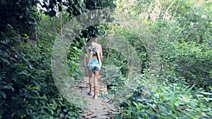 Girl walks to wooden railings through dense old park