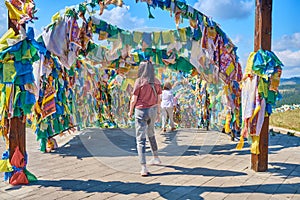 A girl walks under an arch with traditional Buddhist prayer flags in the Rinpoche Bagsha datsan in Ulan-Ude city of the