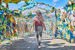 A girl walks under an arch with traditional Buddhist prayer flags in the Rinpoche Bagsha datsan in Ulan-Ude city of the