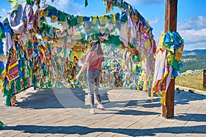 A girl walks under an arch with traditional Buddhist prayer flags in the Rinpoche Bagsha datsan in Ulan-Ude city of the