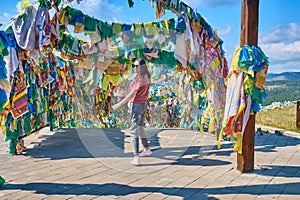 A girl walks under an arch with traditional Buddhist prayer flags in the Rinpoche Bagsha datsan in Ulan-Ude city of the Republic