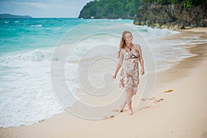 The girl walks on the water`s edge on the Boracay