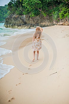 The girl walks on the water`s edge on the Boracay