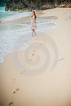 The girl walks on the water`s edge on the Boracay