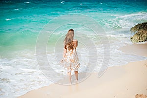 The girl walks on the water`s edge on the Boracay