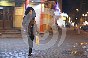 Girl walks in winter night city