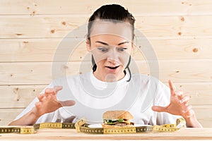 Girl wants a burger. the girl is on a diet. the woman wants to eat a burger.