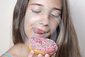 The girl wants to eat donuts. A girl looks with an appetite at a colorful donuts.