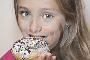 The girl wants to eat donuts. A girl looks with an appetite at a colorful donuts.