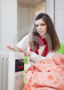 Girl warm hands near radiator