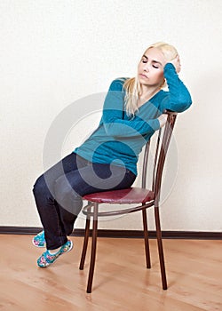 The girl was asleep sitting on a chair