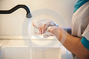 Girl washes her hands with soap to prevent infection with the covid-19 virus