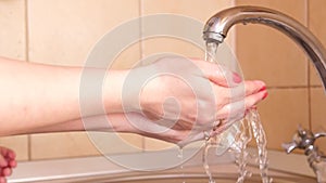 The girl washes her hands with warm water and soap after a walk to prevent germs or viruses from getting through dirty