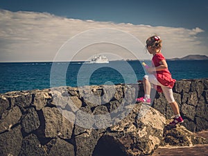 Girl watching ferry on the sea