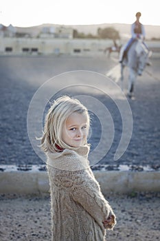 Girl watching a riding lesson