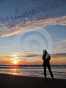 A girl watching sunrise on the beach