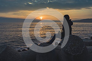 A girl watching a sunrise over the sea in Varna.