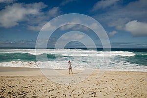 Girl watching the surf on the banzai pipeline on the north shore of the island of Oahu, Hawaii