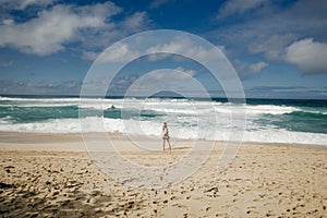 Girl watching the surf on the banzai pipeline on the north shore of the island of Oahu, Hawaii