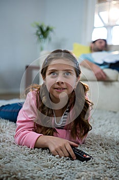 Girl watching tv lying on the rug in the living room