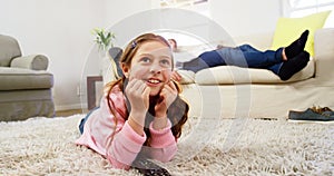 Girl watching tv lying on the rug in the living room